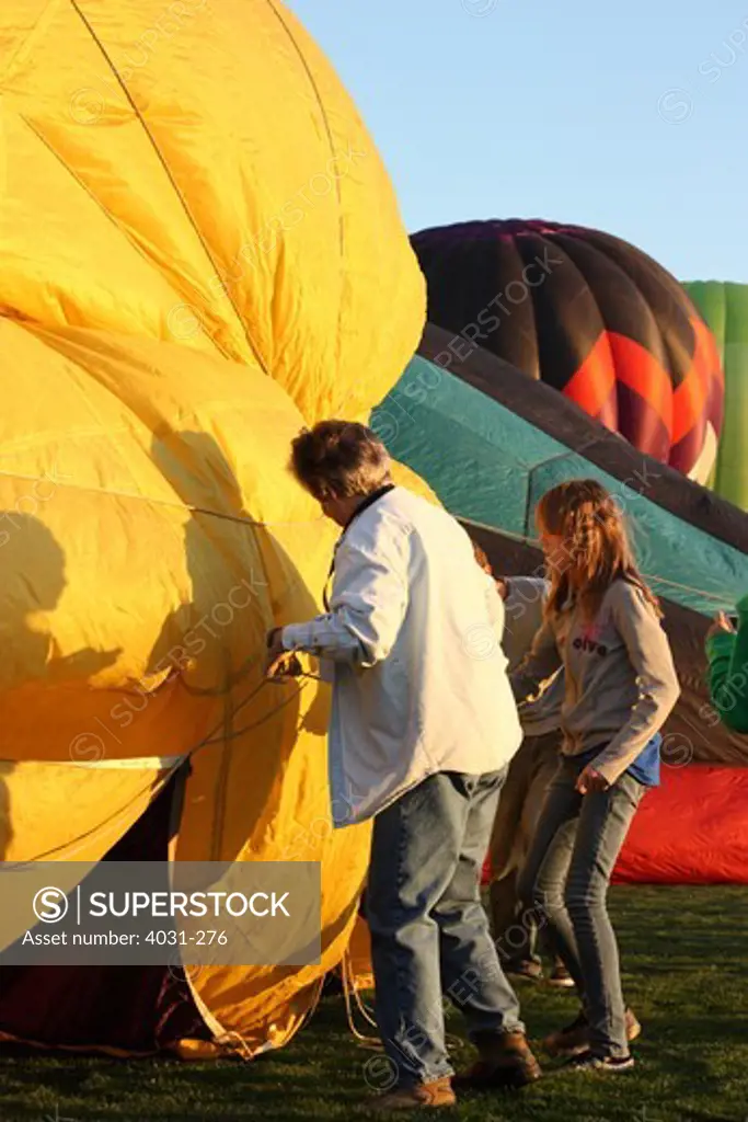 USA, California, Ripon, Crew members adjusting hot air balloon at Color the Skies Hot Air Balloon Festival