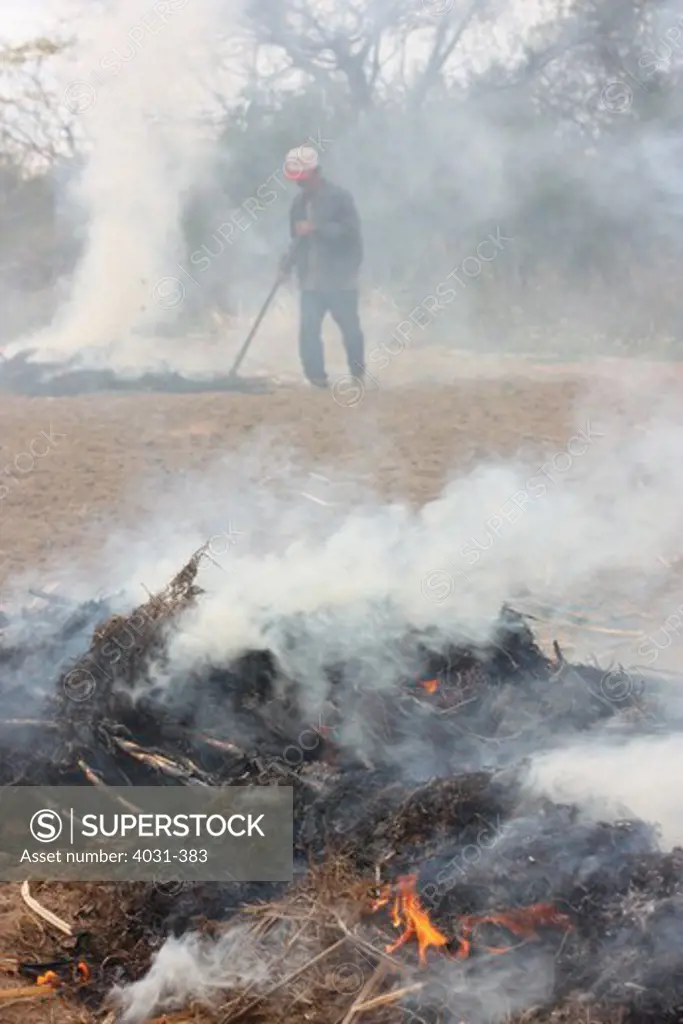 Taiwan, Kinmen County, Farmer burning dried grass