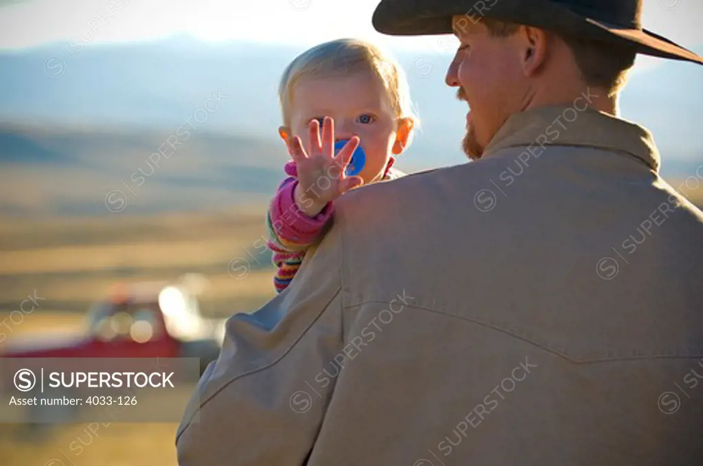 Young man carrying his daughter, Montana, USA