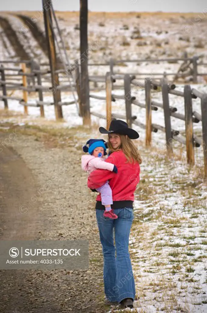 Young woman walking on a road with her daughter, Bozeman, Gallatin County, Montana, USA