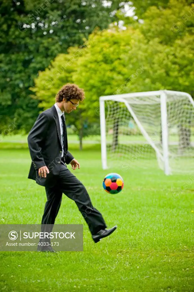 Businessman playing with a soccer ball, Ithaca, New York State, USA