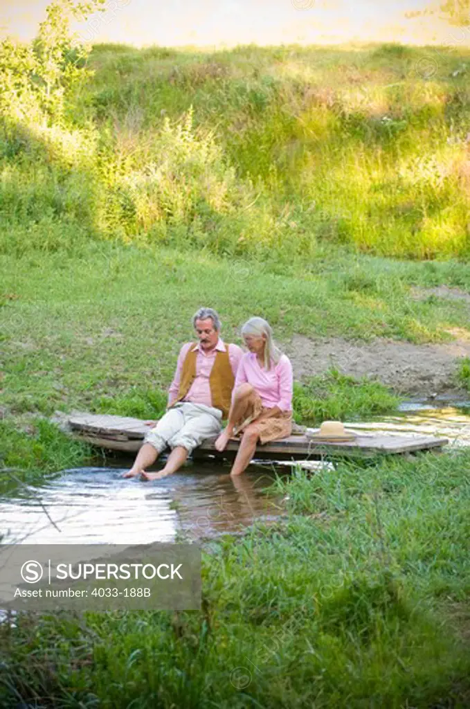 Senior couple snuggling on a bridge across a creek, Bozeman, Gallatin County, Montana, USA