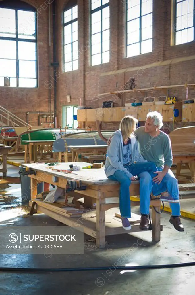 Mid adult couple romancing in a sailboat workshop, Newport, Rhode Island, USA