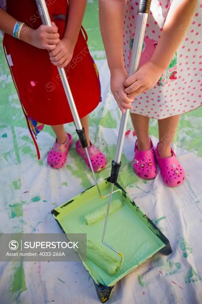 High angle view of two girls holding paint rollers, La Jolla, San Diego County, California, USA