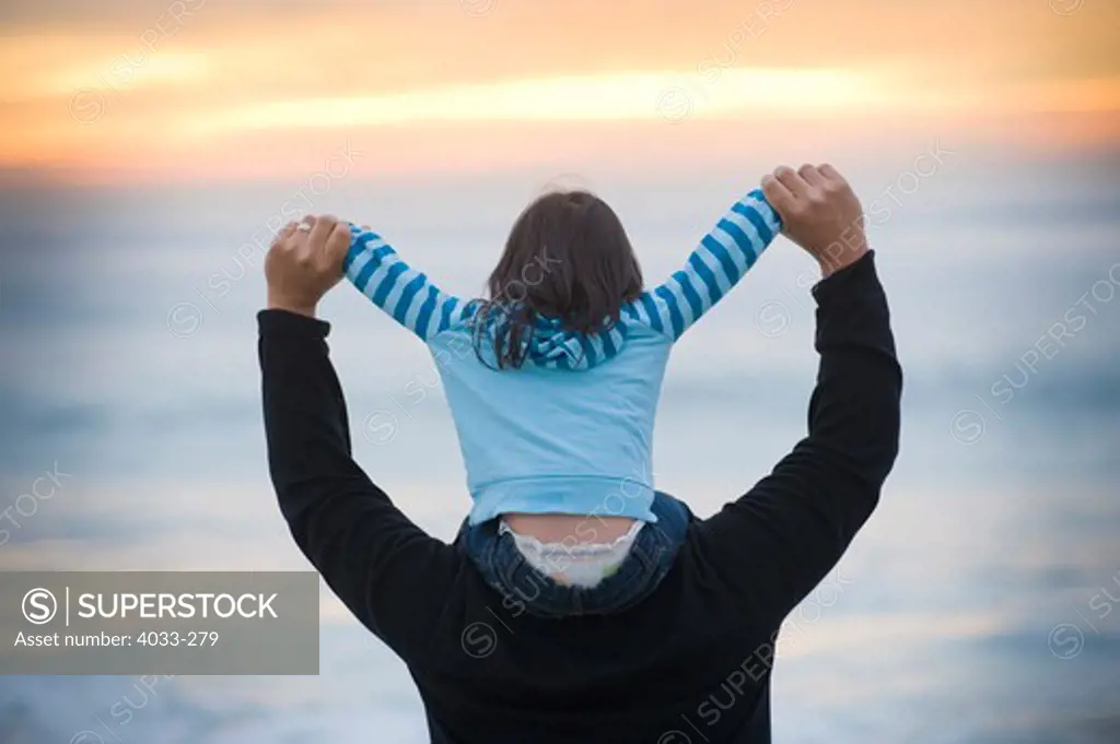 Mid adult man carrying his daughter on his shoulders, La Jolla, California, USA