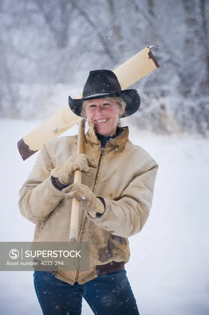 Mature woman smiling with a snow shovel, Bozeman, Montana, USA