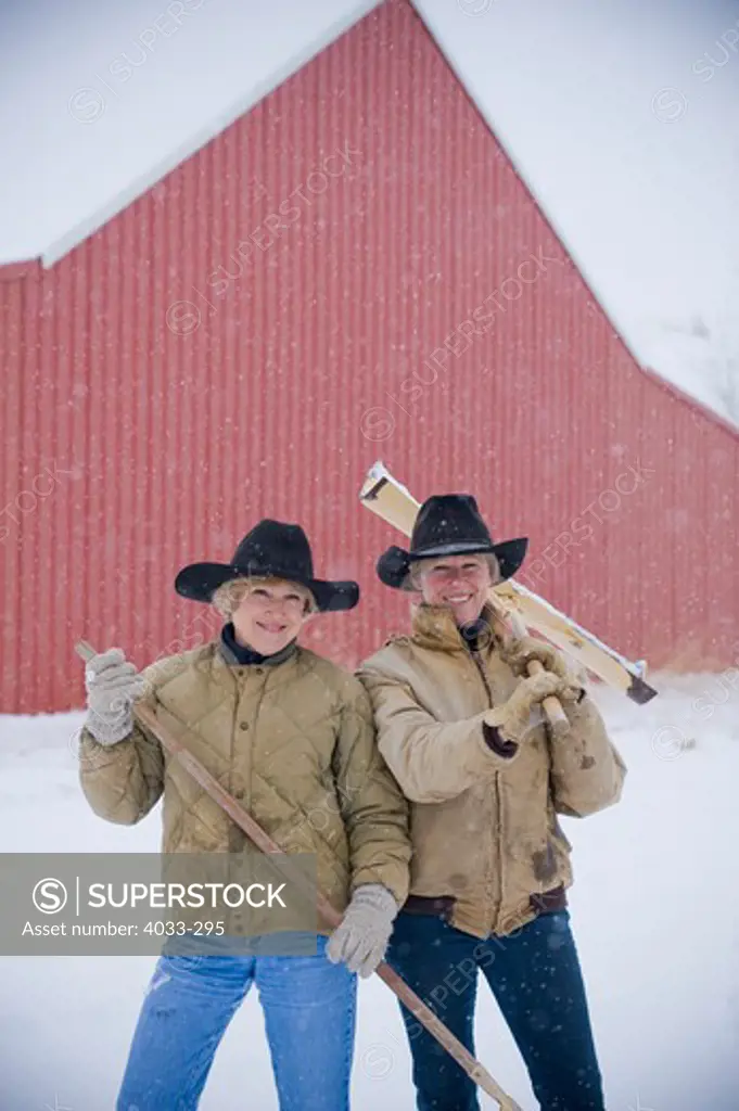 Mature women smiling with a snow shovel, Bozeman, Montana, USA