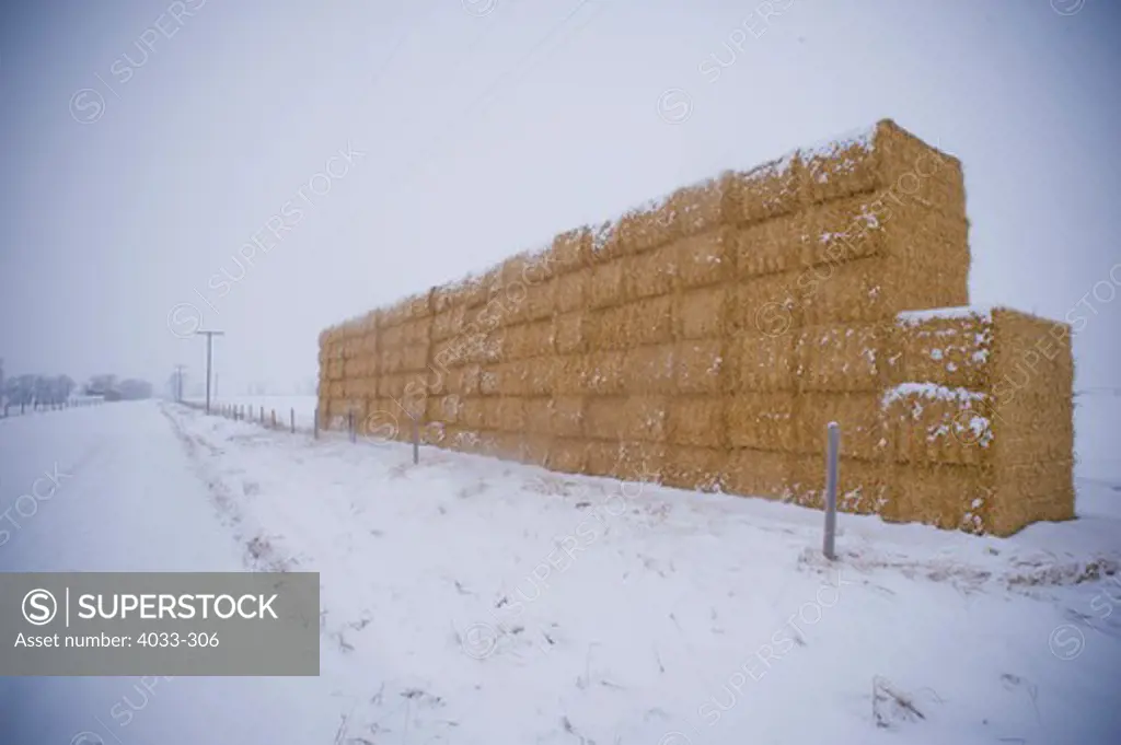Haystacks at the roadside in snow, Bozeman, Montana, USA