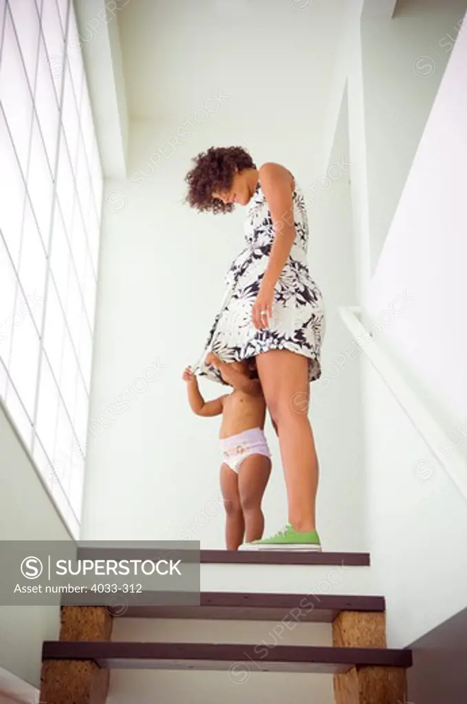 Low angle view of a pregnant woman standing with her daughter, San Diego, California, USA