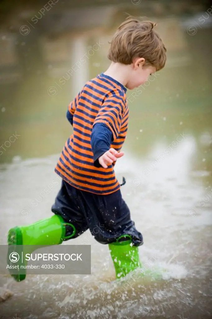 Boy playing in a puddle, San Diego, California, USA