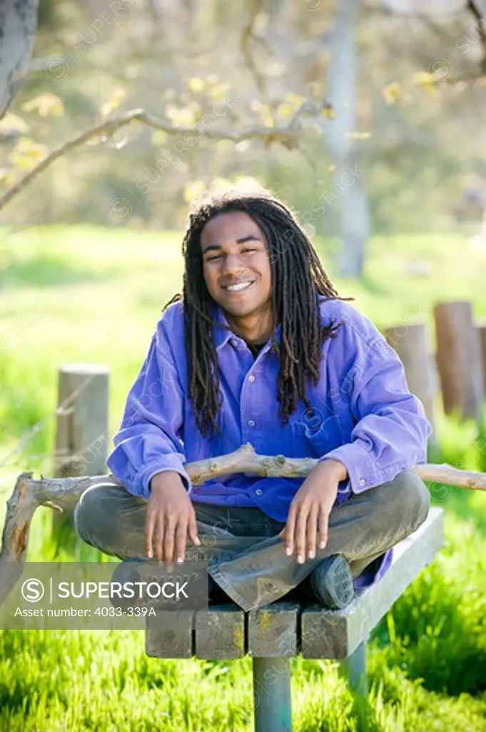 Young man sitting on a park bench, San Diego, California, USA