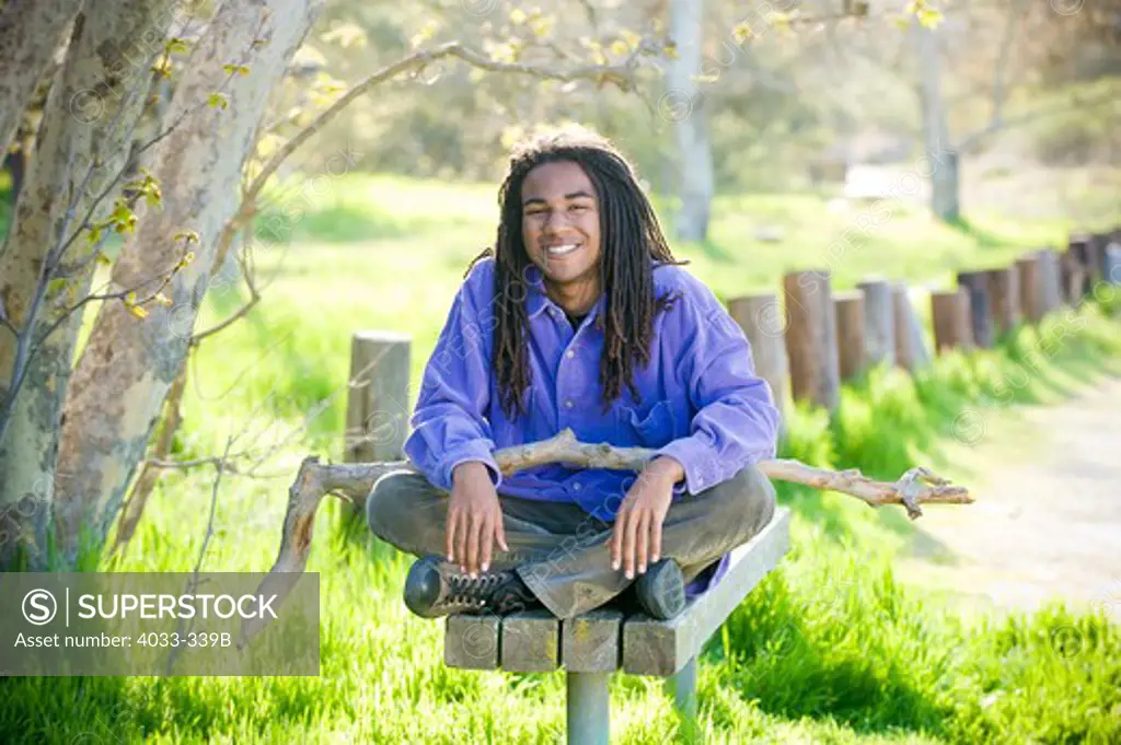 Young man sitting on a park bench, San Diego, California, USA