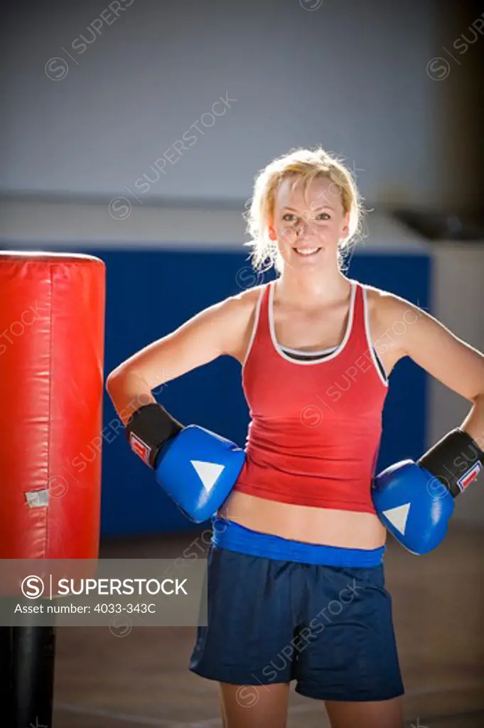 Female kickboxer standing with punching bag in a gym, Bozeman, Montana, USA