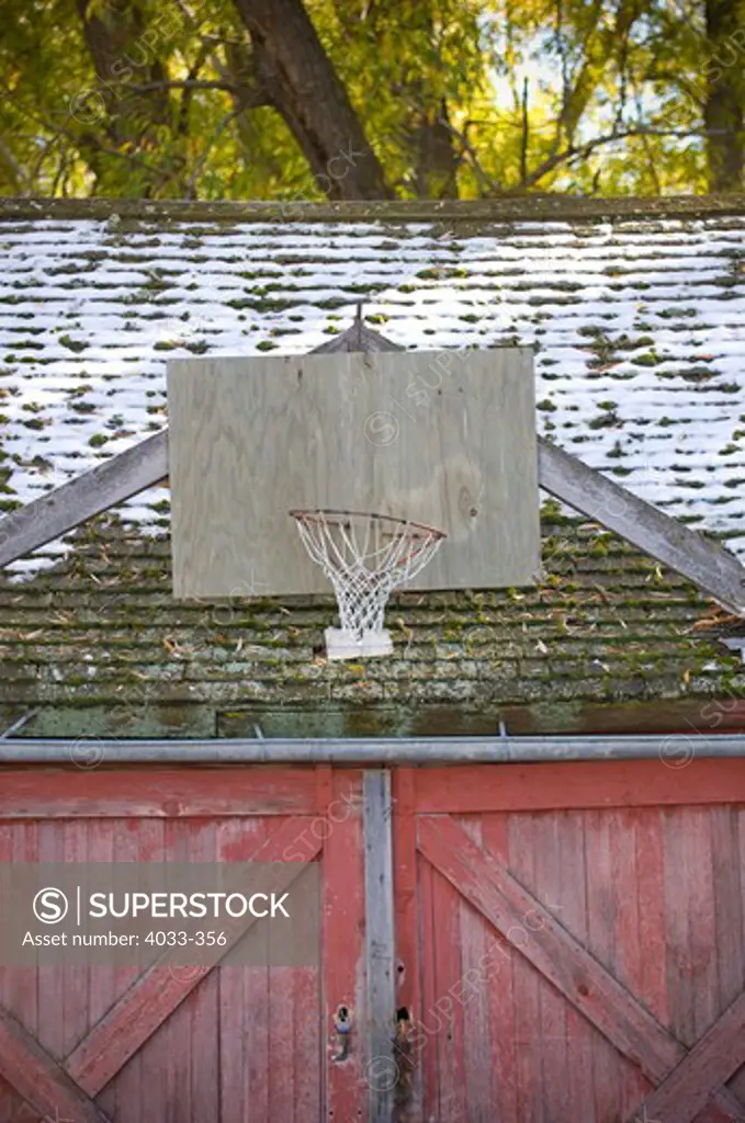 Barn with basketball hoop and snow, Bozeman, Montana, USA