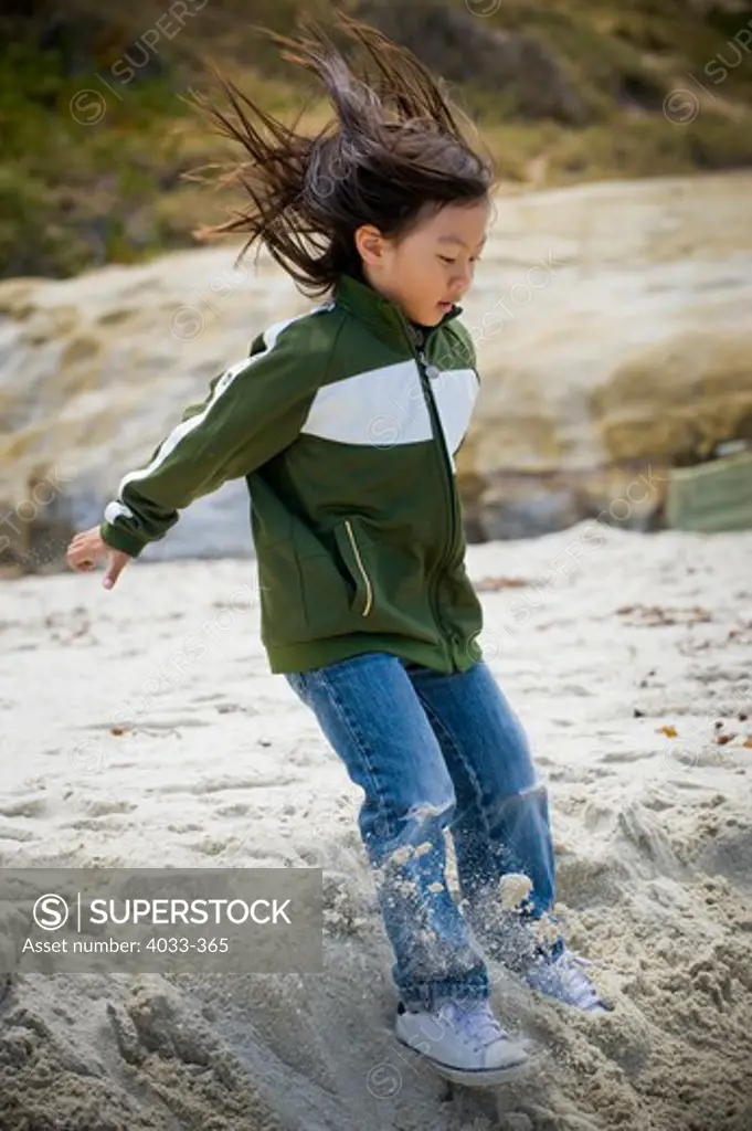 Boy jumping on sand on the beach, San Diego, California, USA