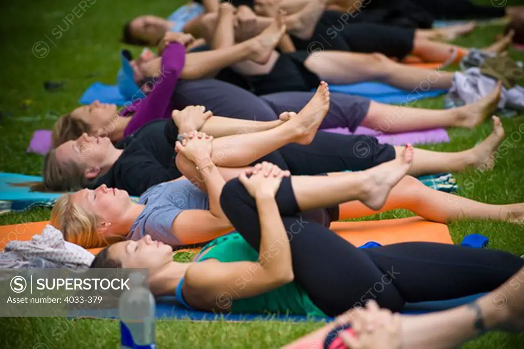 Group of people practicing yoga in a park, San Diego, California, USA