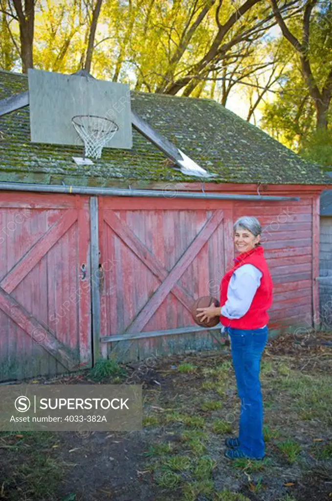 Mature woman holding basketball, Bozeman, Montana, USA