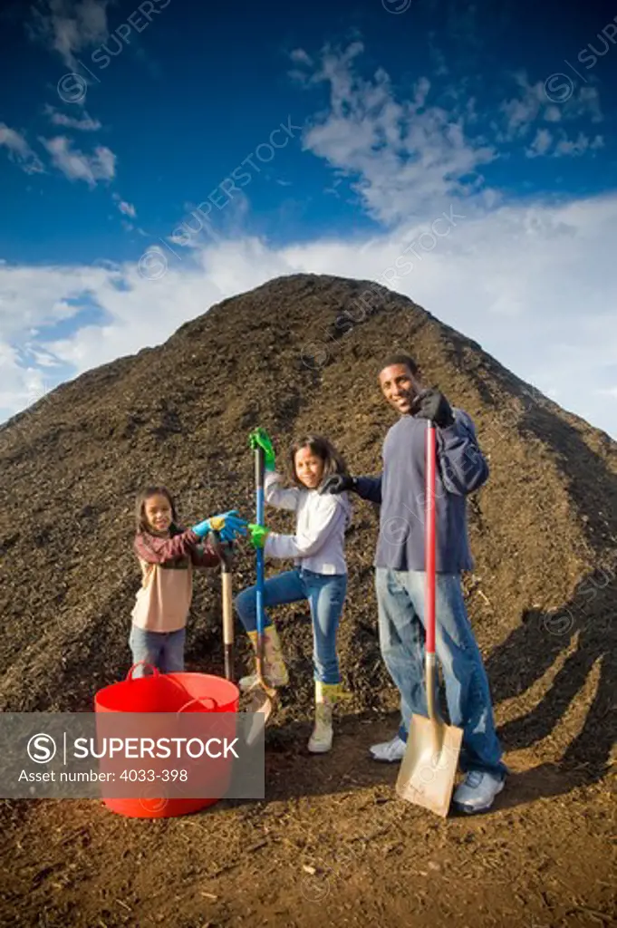 Family in front of a heap of compost
