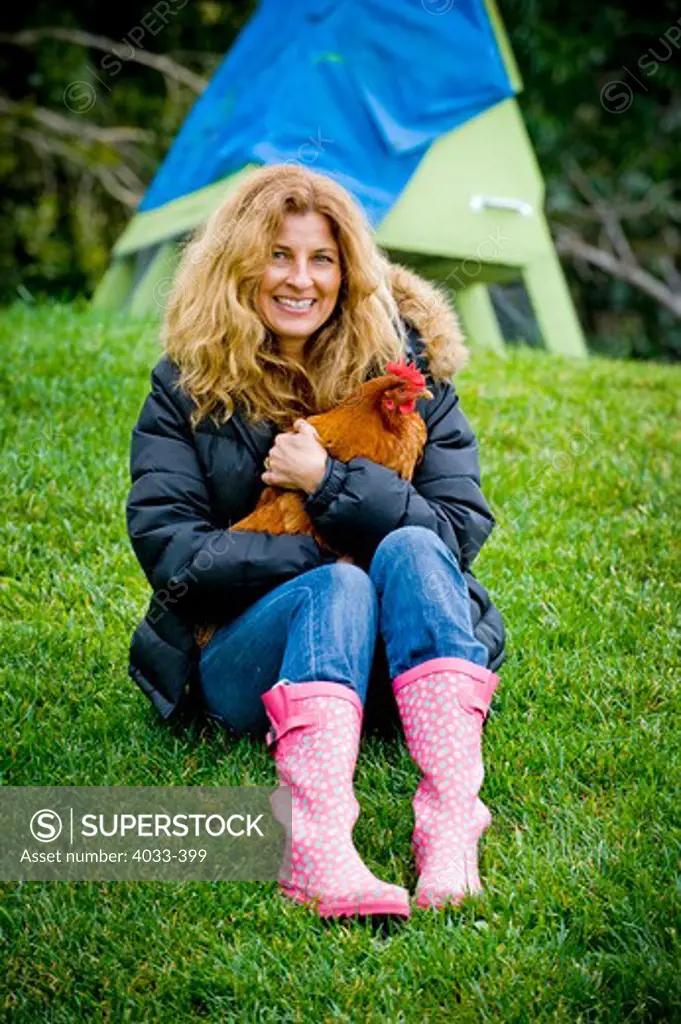 Mid adult woman holding a hen