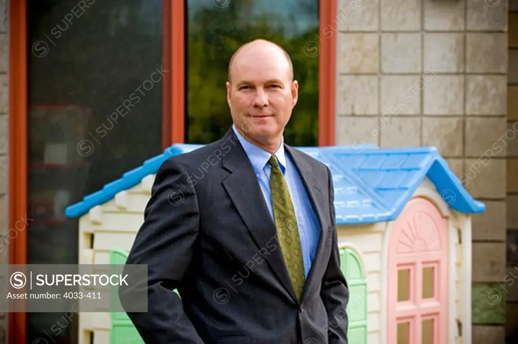 Portrait of a businessman standing in front of a model home