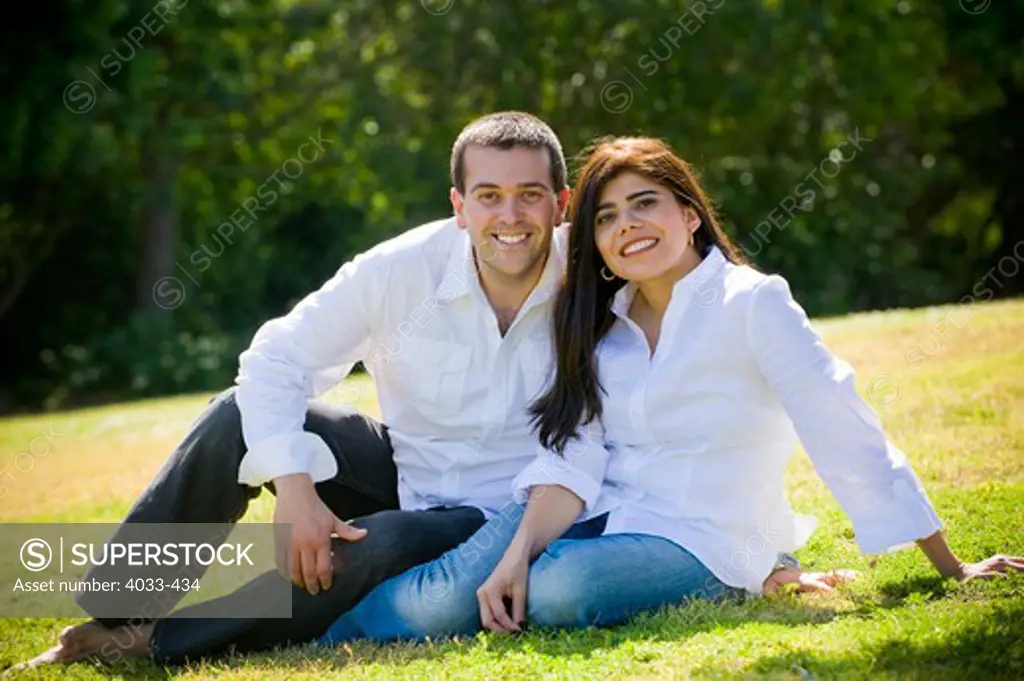 Mid adult couple sitting together in a field