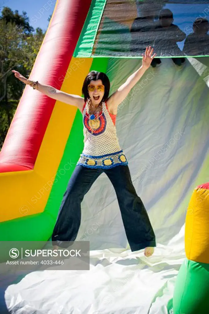 Young woman jumping on an inflatable slide