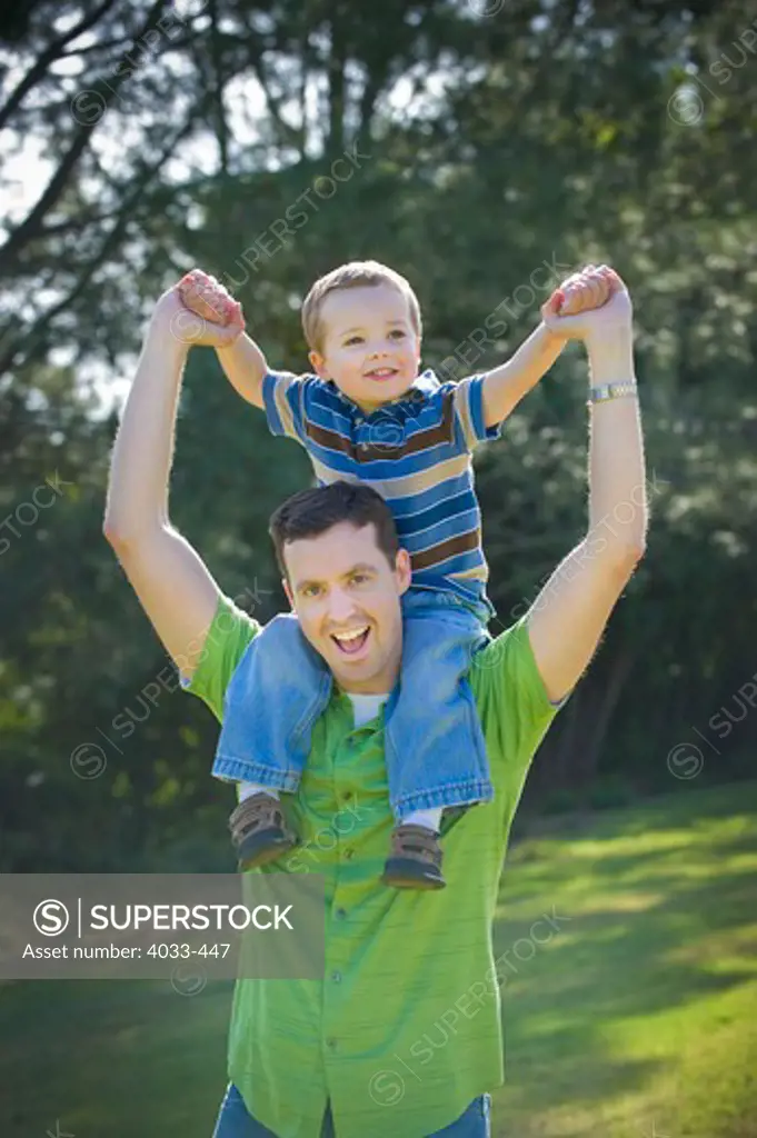 Mature man carrying his son in a park