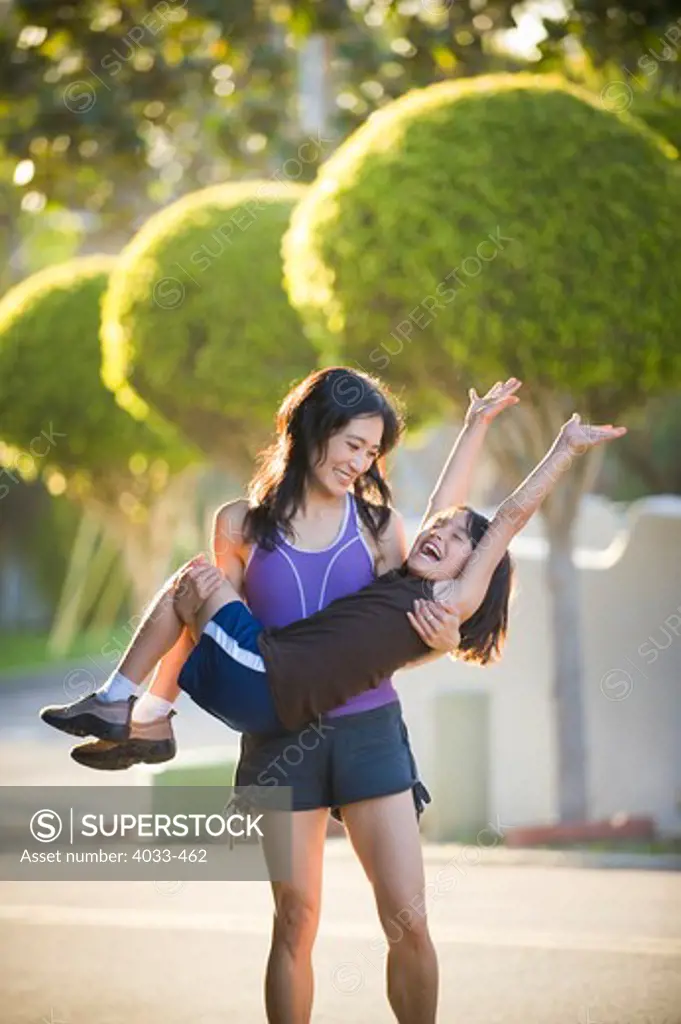 Mid adult woman playing with her daughter in a park