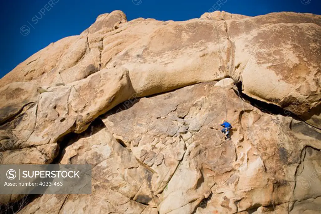 Girl rock climbing, Joshua Tree National Monument, California, USA