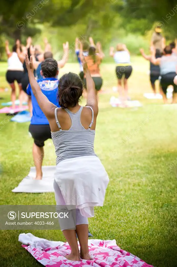 People practicing yoga in a park