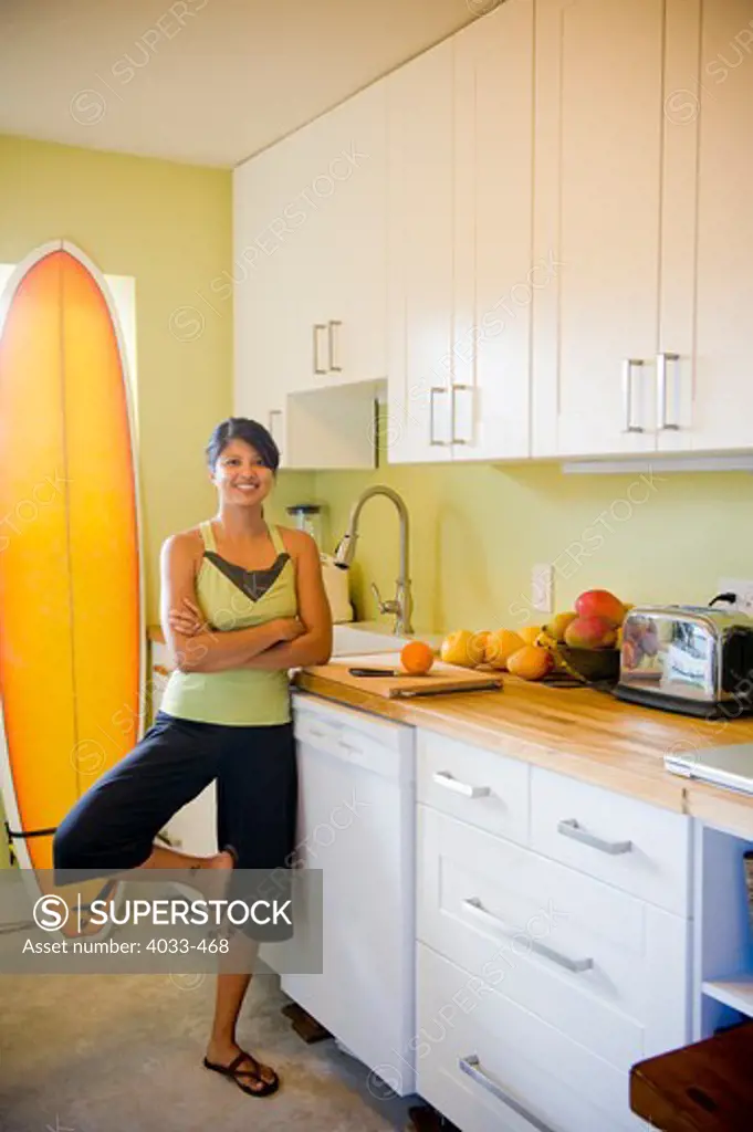 Young woman practicing yoga in kitchen