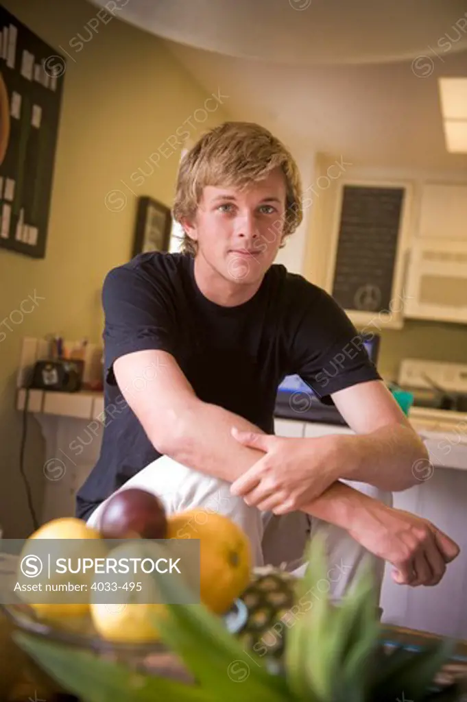Teenage boy sitting in the kitchen