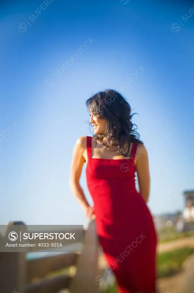 Mid adult woman standing on the beach looking at view