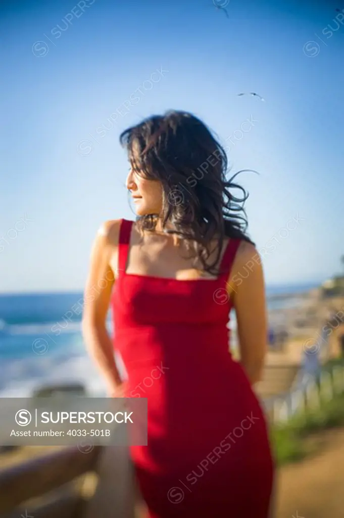 Mid adult woman standing on the beach looking at sea view