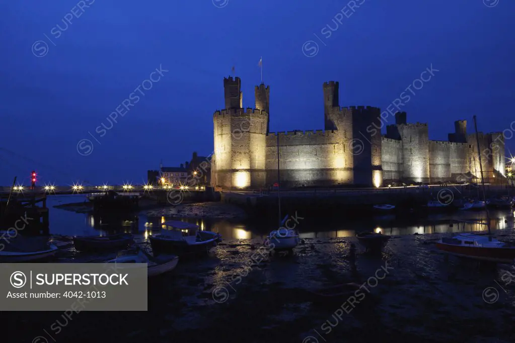 Castle lit up at night, Caernarfon Castle, Caernarfon, Gwynedd, Wales