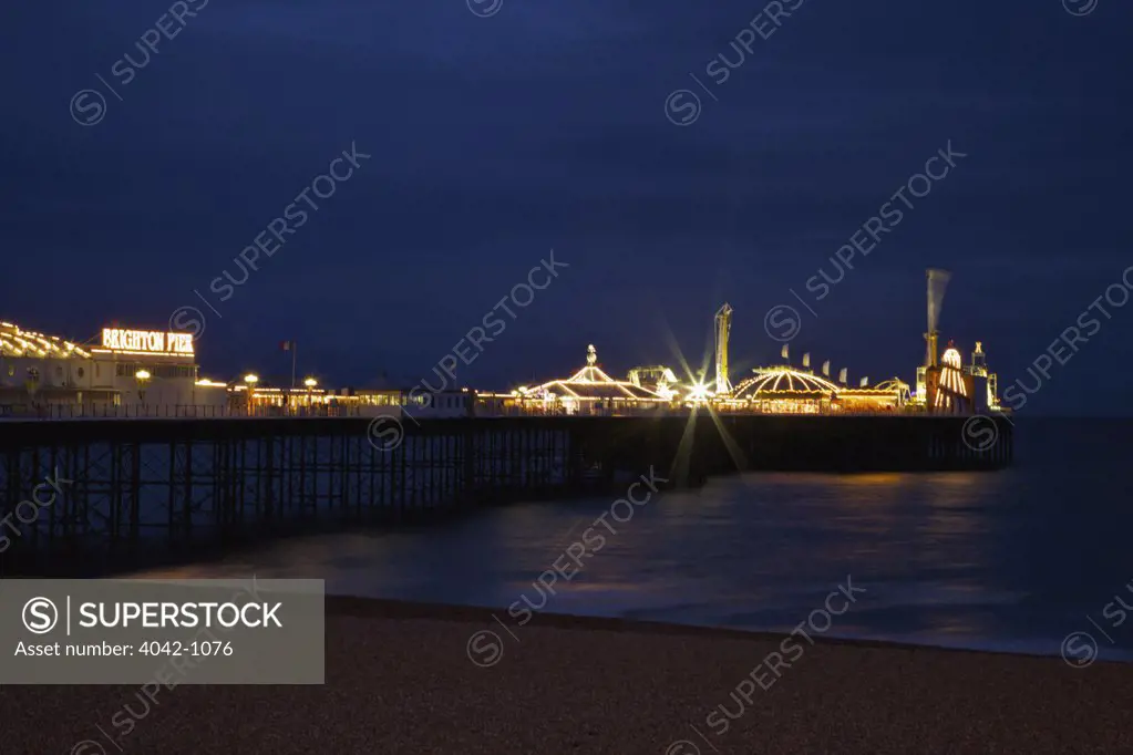 Pier lit up at dusk, Palace Pier, Brighton, Sussex, England