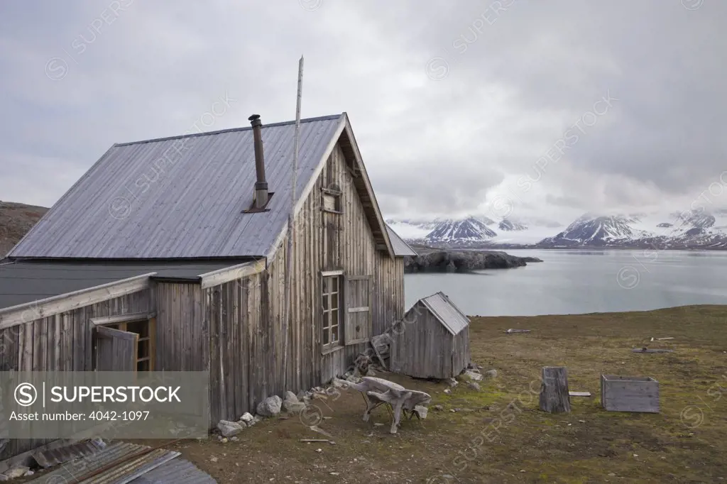Old wooden trapper's hut on the coast, Camp Mansfield, Blomstrandhalvoya, Spitsbergen, Svalbard Islands, Norway