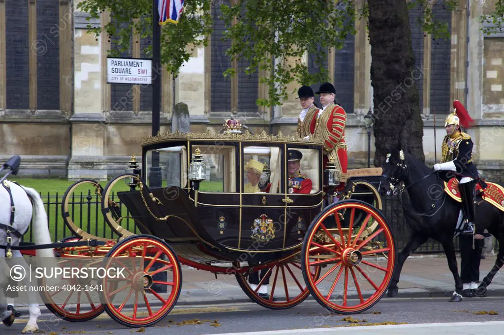 Queen Elizabeth II and the Duke of Edinburgh travel in the Scottish State Coach outside of Westminster Abbey for participating in marriage of Prince William to Kate Middleton on 29th April 2011, London, England