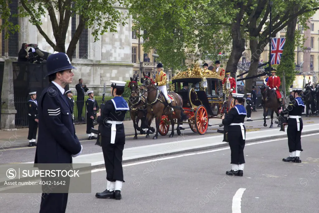 Royal carriage carries Prince Charles and Camilla with Michael and Carole Middleton outside of Westminster Abbey for participating in marriage of Prince William to Kate Middleton on 29th April 2011, London, England
