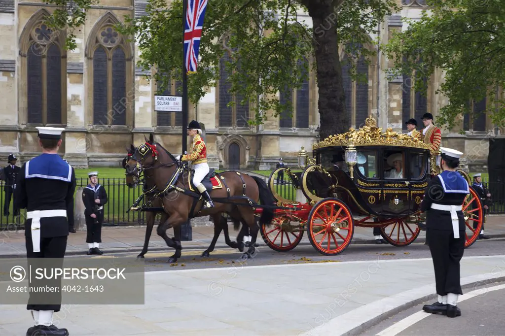 Royal carriage carries Prince Charles and Camilla with Michael and Carole Middleton outside of Westminster Abbey for participating in marriage of Prince William to Kate Middleton on 29th April 2011, London, England