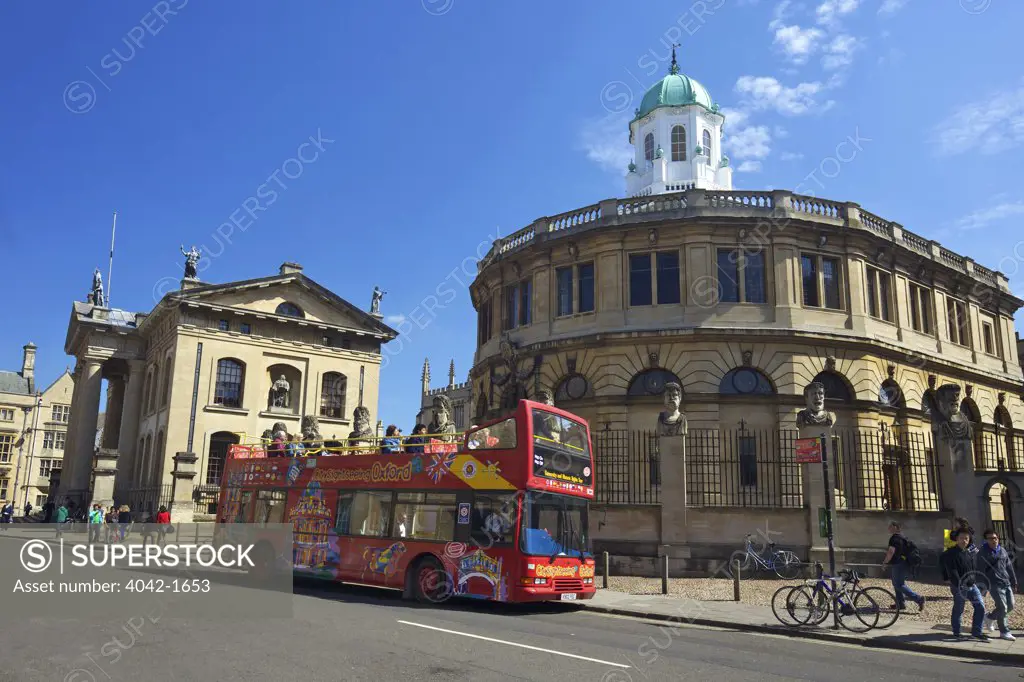 Open top bus on the road outside a theatre, Sheldonian Theatre, Clarendon Building, Broad Street, Oxford University, Oxfordshire, England