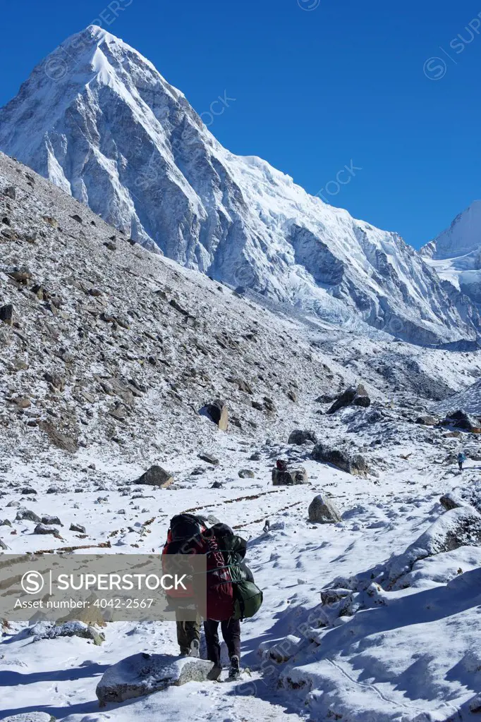 Trekkers walking up trail to Everest Base Camp with Pumori behind, Sagarmatha National Park, Solukhumbu District, Nepal