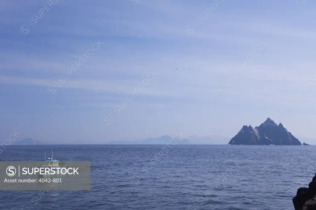 Fishing boat in the sea with rock formations in the background, Skellig Michael, County Kerry, Munster Province, Republic Of Ireland