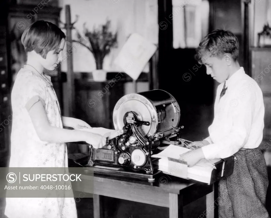 School children work on a mimeograph machine. Thomas Edison had two patents for an 'Autographic Printing' that worked by forcing ink through a stencil onto paper with low-cost printing press. The word 'mimeograph' was first used by Albert Blake Dick when he licensed Edison's patents in 1887. May 7, 1930.