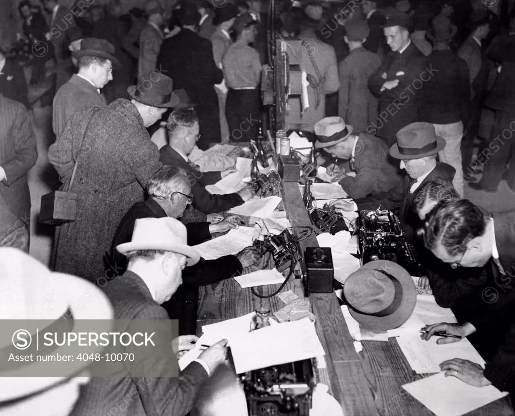 First reports of the Hindenburg disaster. Newspaper men and telegraph operators work together in the pressroom of Lakehurst Naval Air Station to report the Hindenburg disaster. May 6, 1937.