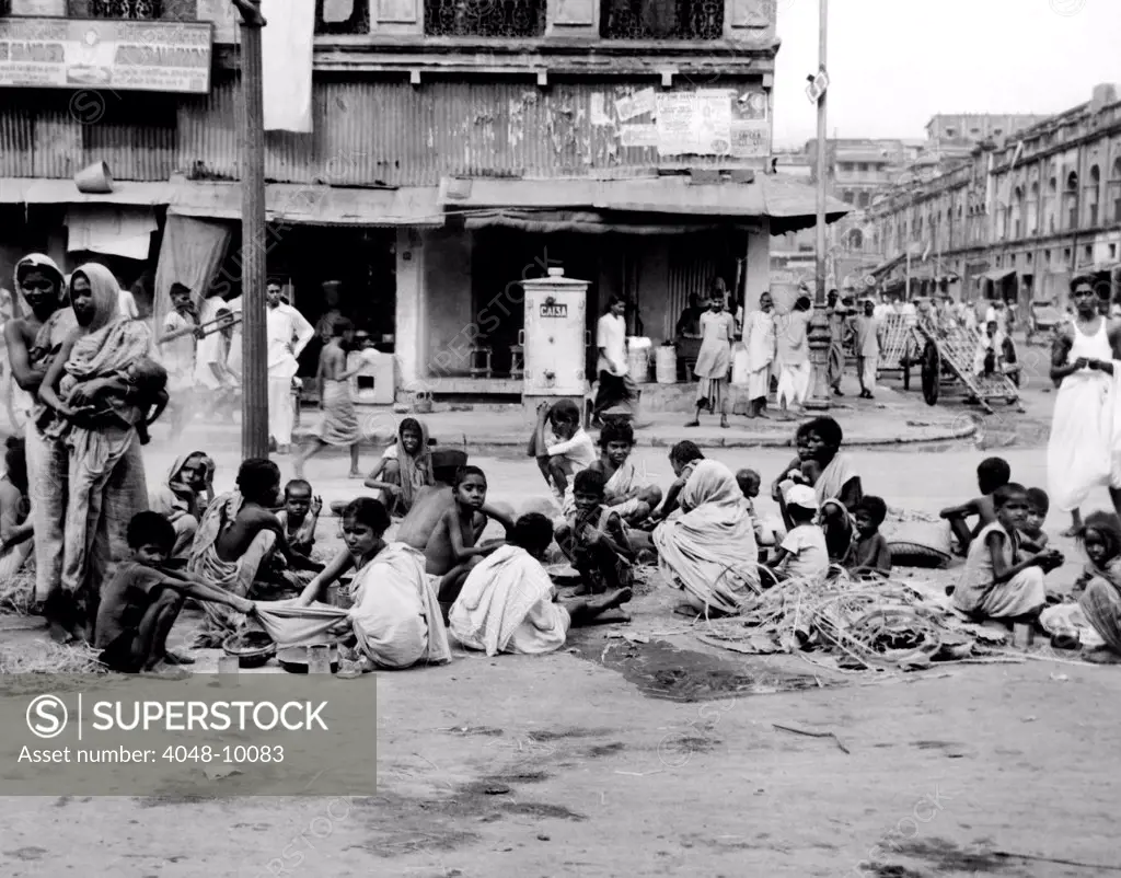 At the peak of India's famine in late October 1943, Starving homeless people huddle in a Calcutta street. An estimated 1,000,000 persons had died of starvation in India, in one week.
