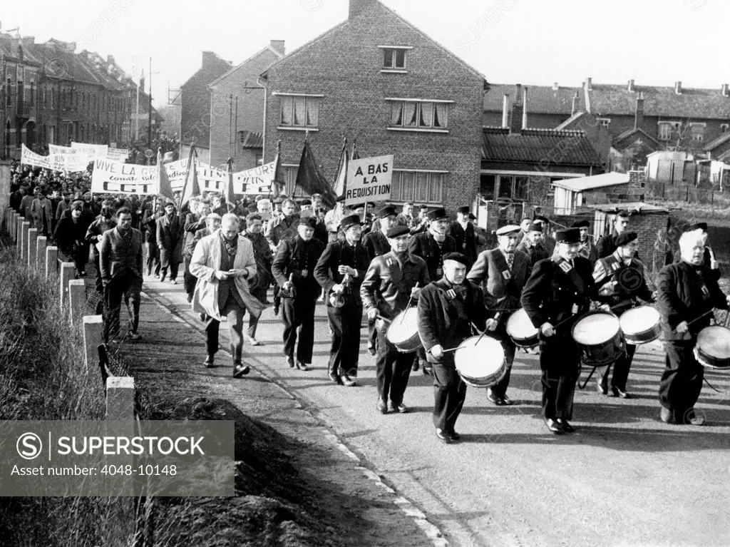 Striking coal workers march in Wingles, France. 200,000 coal miners were on strike and rejected the government's offer of an 8 percent wage increase spread over six months. March 25, 1963