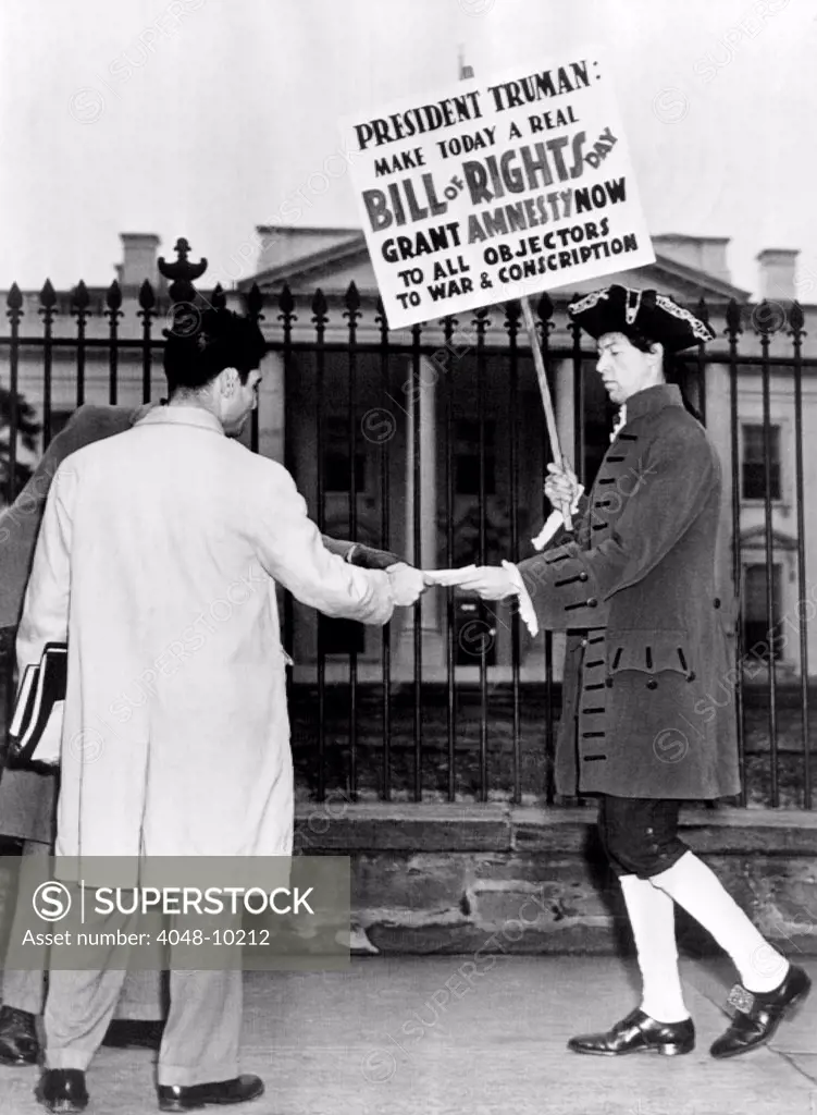 Nathan Horowitz pickets the White House for the Committee for Amnesty of War Objectors. Dressed in a Revolutionary War costume, his sign reads, 'President Truman, Make Today a True Bill of Rights Day. Grant Amnesty Now to All Objectors to War and Conscription.' Dec. 15, 1947.