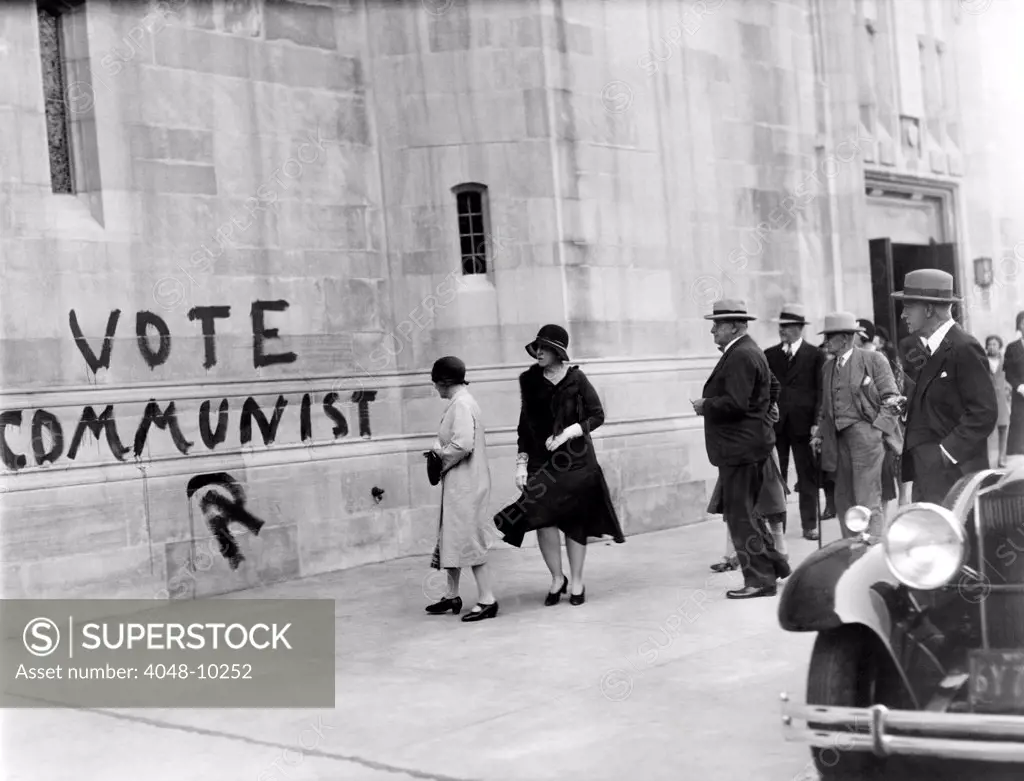 VOTE COMMUNIST' is painted on the Church of Heavenly Rest on Fifth Ave. and 90th Street. Wealthy parishioners observe the sign as they leave the church after the morning service. Nov. 4, 1930.