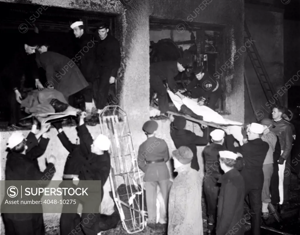 Coconut Grove Nightclub Fire. Service men assist in the removal of bodies from through the charred windows of the burned out building. Nov. 29, 1942.